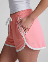 pink 2.5" inseam short with an encased elastic at waistband with drawcord, self binding at hem edges, side zipper pockets, and interior performance lining shorts.